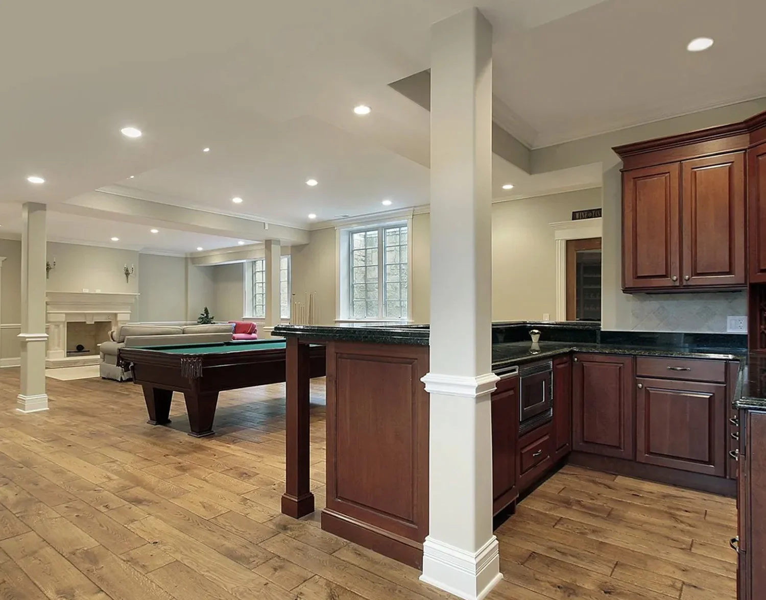 A room with a pool table and bar in it