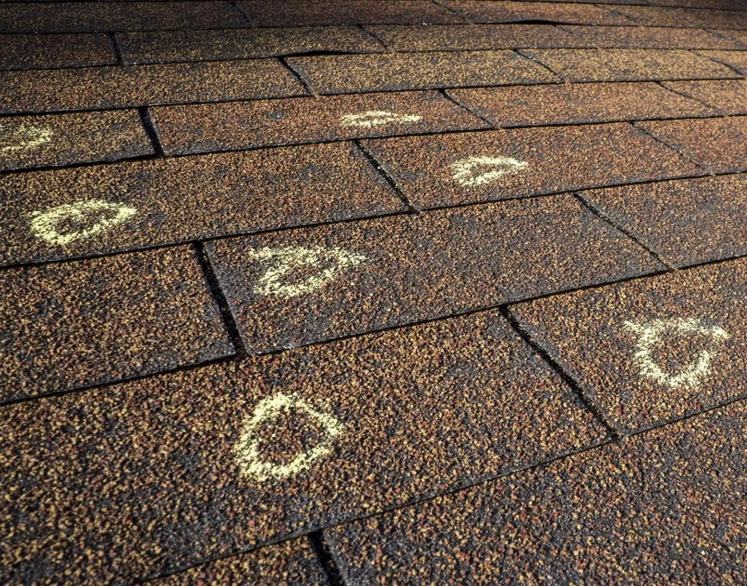 A close up of the asphalt roof with white circles drawn on it.